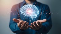 Businessman holding glowing digital brain with neural connections and light effects representing artificial intelligence and innovation in technology.