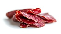 Thinly sliced cured meat pieces arranged on white background showing texture and marbling of premium dried beef or pork charcuterie product for food photography.