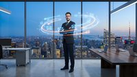Businessman in dark suit standing in modern high-rise office with city skyline view, interacting with glowing digital holographic interface displaying data analytics and global network connections.