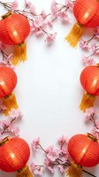 Red paper lanterns with golden tassels and pink cherry blossom branches creating decorative frame on white background for Asian celebration designs.