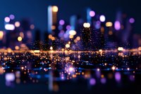 Dreamy urban nightscape with glowing bokeh lights reflecting on water surface, city skyline silhouettes against dark blue sky create magical atmosphere.