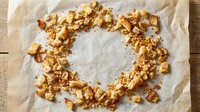 Homemade caramel popcorn arranged in a circle on parchment paper, perfect for food photography, snack packaging, and culinary content.