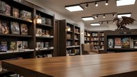 Modern bookstore interior with wooden table, bookshelves and track lighting creating cozy reading atmosphere for retail business design.