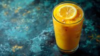 Fresh orange juice with ice cubes and citrus slice in tall glass on dark turquoise textured background with copy space. Summer refreshing drink.