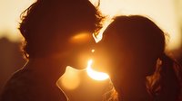 Romantic couple silhouette touching foreheads at golden sunset, intimate moment of love and connection for wedding, anniversary, relationship concepts.
