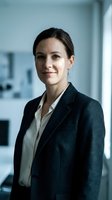 Professional businesswoman in dark suit smiling confidently in modern office environment for corporate and career success concepts.