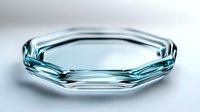 Minimalist geometric glass plate with faceted edges and aqua blue tint on white background, modern tableware design for luxury dining and home decor.