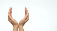 Two open hands positioned upward in protective gesture on white background, symbolizing care, support and offering help in business or healthcare.