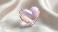 Iridescent glass heart with rainbow reflections on soft pink silk fabric creating romantic luxury aesthetic for wedding and love concepts.
