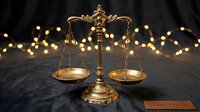 Golden scales of justice on dark surface with warm bokeh lights creating elegant legal concept for law firms and judicial services.