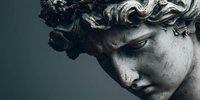 Classical marble statue head with curly hair showing Renaissance sculpture artistry and ancient Greek Roman architectural detail for educational content.