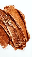 Copper metallic paint strokes with textured brushwork and shimmering finish on white background. Use for cosmetics, beauty, luxury branding, and artistic design projects.