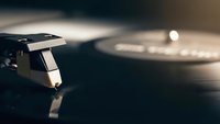 Vintage turntable needle on vinyl record with warm lighting creating nostalgic atmosphere for music production and audio entertainment concepts.