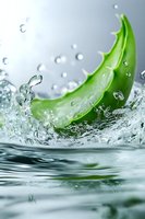 Fresh aloe vera leaf splashing in clear water with dynamic water drops and ripples, creating refreshing movement against light background.