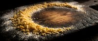 Freshly baked round cake dusted with powdered sugar on dark surface, ideal for bakery, food photography, and culinary content.