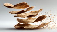 Floating pieces of dried coconut shell or husk against neutral background, creating dynamic layered composition with natural brown tones.