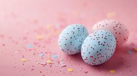 Speckled pastel blue Easter eggs decorated with colorful dots and confetti scattered on pink background, festive spring holiday celebration composition.