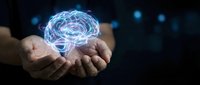 Glowing digital brain hologram floating above cupped hands against dark background with blue light effects for technology and artificial intelligence concepts.