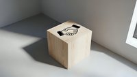 Wooden cube with handshake icon on top surface in modern minimalist interior setting for business partnership and collaboration concepts.