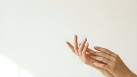 Two hands with medium skin tone gesturing expressively against a neutral beige background, suitable for wellness, communication, and lifestyle content.