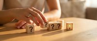 Business problem solving concept with wooden blocks showing question marks transforming to lightbulb idea on desk for strategic planning and innovation.