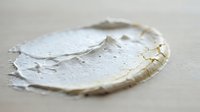 Closeup of white textured paint stroke or plaster sample with rough edges and organic shape on neutral background, suitable for design, art, and creative projects.