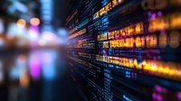 Glowing computer code lines on dark background with colorful bokeh light effects and selective focus, representing digital technology and programming.