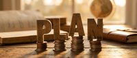 Financial planning concept with wooden PLAN letters and coin stacks on desk with warm sunlight creating investment strategy atmosphere for business growth.
