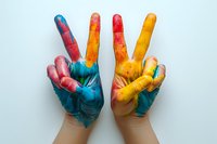 Colorful painted hands showing peace and victory signs against white background, expressing creativity, joy and positive vibes through vibrant paint colors.