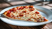 Slice of pepperoni pizza with melted mozzarella cheese on white plate, close up view showing crispy crust and savory toppings on rustic wooden table.