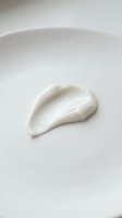 White cream or lotion sample smeared on clean surface, showcasing skincare product texture and consistency for cosmetics, beauty, and dermatology applications.