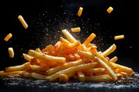 Golden french fries sprinkled with salt in dynamic composition against dark background with flying pieces and dramatic lighting for food advertising.