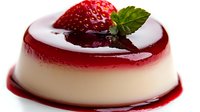 Creamy panna cotta dessert topped with fresh strawberry, mint leaf and red berry sauce, featuring smooth texture and glossy mirror glaze finish.