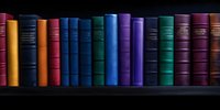 Row of vintage hardcover books arranged on dark wooden shelf, displaying colorful spines in yellow, blue, green, and purple against black background. Classic library collection.