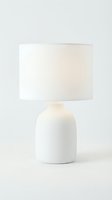 Minimalist white ceramic table lamp with drum shade on a clean light background, for home decor and interior design concepts.
