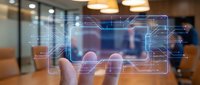 Hand holding transparent digital interface with circuit patterns in modern office environment for technology and business applications.