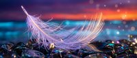 Delicate white feather floating above colorful pebbles on beach at sunset with dramatic sky and ocean waves creating magical atmospheric scene.