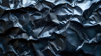 Dark blue crumpled paper texture with dramatic shadows and highlights creates abstract pattern of folds and creases for artistic backgrounds and designs.