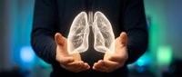 Professional man in dark suit holding glowing transparent lungs between cupped hands against blurred blue green background for healthcare concepts.