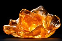 Amber glass sculpture with flowing organic form glowing against dark background, contemporary art piece with warm golden translucent material and smooth curves.