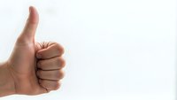 Hand showing thumbs up gesture on white background for positive feedback and approval concepts in business presentations.