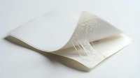 Curved white paper sheet with printed text creating elegant wave motion on clean background for modern design projects.