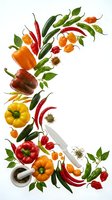 Fresh assorted peppers, chili peppers, and spices arranged with mortar and pestle on white background for cooking and culinary content.