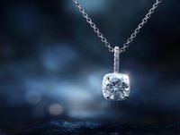 Elegant diamond pendant necklace with round brilliant cut stone in white gold setting against dark blue bokeh background, luxury jewelry photography.