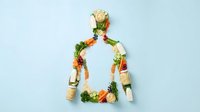 Human silhouette made from fresh vegetables and supplements on light blue background. Healthy lifestyle and nutrition concept for wellness design.