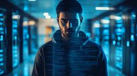 Young Middle Eastern man in hoodie standing in dark corridor with dramatic blue neon lighting and digital glitch effect creating mysterious cyberpunk atmosphere.