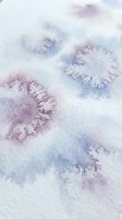 Soft watercolor texture with purple and blue paint stains on white paper creating organic abstract patterns for artistic backgrounds and creative projects.