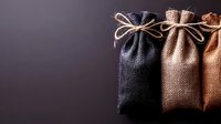 Rustic burlap sacks tied with natural rope against dark background for packaging design and eco-friendly storage solutions.