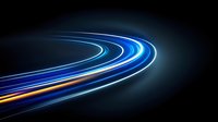 Curved light trails glowing in blue and orange colors against dark background create dynamic motion effect, suitable for technology and speed concepts.
