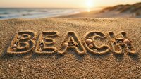Word BEACH carved in golden sand decorated with seashells and starfish at sunset, ocean waves and warm sunlight in background.